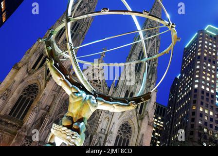 Una scultura dell'Atlante greco del dio che regge il mondo si trova nel Rockefeller Center, di fronte alla cattedrale di St Patrick a New York City Foto Stock