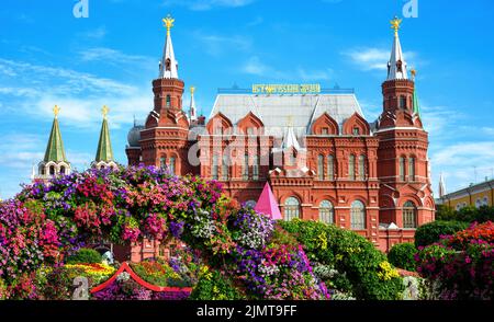 Fiori su Piazza Manezhnaya, Mosca, Russia. Museo storico (è scritto sul tetto) sullo sfondo, antico punto di riferimento di Mosca. Vista panoramica di festive Foto Stock