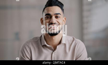 Felice ragazzo gioioso ispanico arabo bello giovane uomo modello casual con sorriso toothy guardare fotocamera ottimista volto maschile ritratto sorridente uomo d'affari Foto Stock