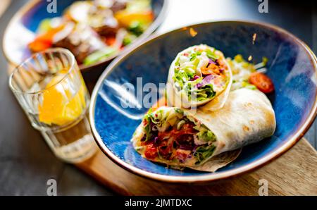 Una ciotola con due pezzi di tortilla vegetariana Foto Stock