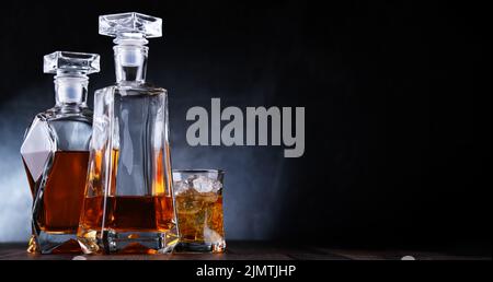 Composizione con un bicchiere e due decantatori di whiskey Foto Stock