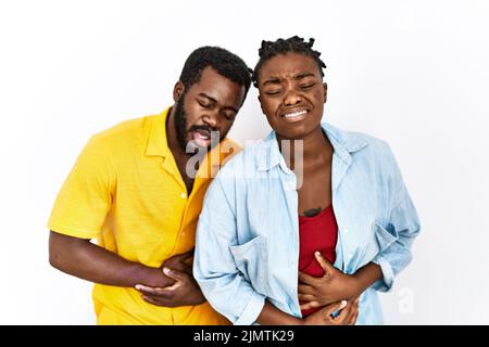 Giovane coppia afroamericana che indossa abiti casual con mano sullo stomaco perché nausea, malattia dolorosa sensazione di malessere. Mal concetto. Foto Stock