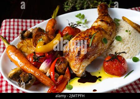 Cosce di pollo fritte rustiche con verdure assortite e riso Foto Stock