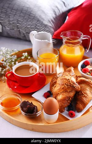 Un vassoio con la prima colazione su un letto in una camera d'albergo. Foto Stock