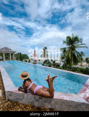 Coppia uomini e donne che si rilassano in piscina durante una vacanza di lusso in Thailandia Foto Stock