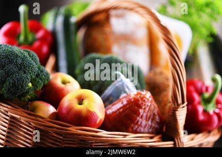 Cesto di vimini con prodotti alimentari assortiti, tra cui verdure fresche e. frutta Foto Stock