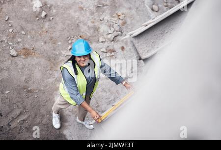 Stavano andando tutto verso l'alto. Ritratto ad angolo alto di una giovane e attraente lavoratrice di costruzione che lavora in loco. Foto Stock