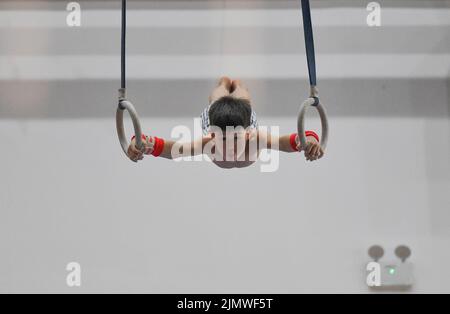 FUYANG, CINA - 7 AGOSTO 2022 - Un bambino pratica la ginnastica si muove alla palestra del Fuyang Vocational and Technical College nell'Anhui della Cina orientale Foto Stock