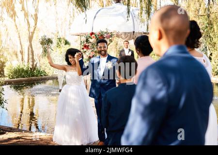 La forza dell'amore ci ha portato tutti qui oggi. Una giovane coppia felice newlywed che cammina giù la navata davanti agli ospiti il giorno del loro matrimonio. Foto Stock