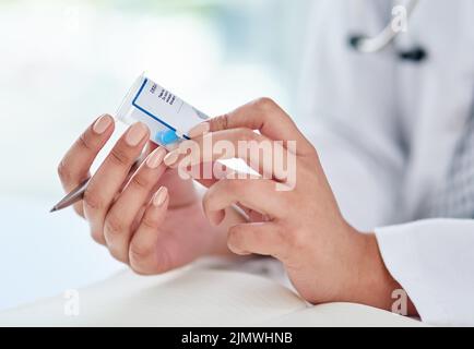 Il farmaco è abituato alle esigenze dei suoi pazienti. Un medico che compila una prescrizione nella sua stanza di consulenza. Foto Stock