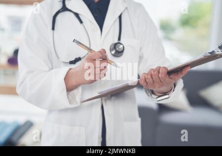 Prepararsi a vedere la sua prossima paziente. Una donna irriconoscibile medico scrivere su una clipboard mentre si trova in ufficio. Foto Stock