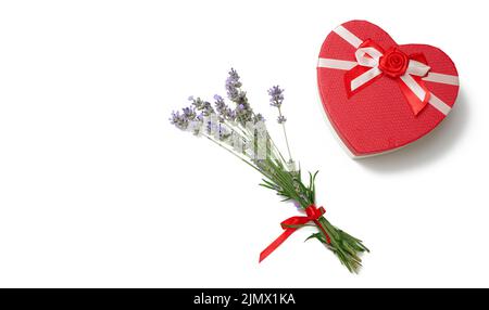 Bouquet di lavanda e scatola regalo rossa di cartone a forma di cuore su sfondo bianco, vista dall'alto Foto Stock