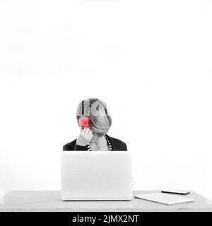 Donna che ha mal di testa mentre lavora un notebook Foto Stock