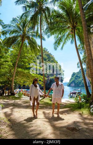 Koh Lao Lading nei pressi di Koh Hong Krabi Thailandia, bella spiaggia con barche a coda lunga, coppia di uomini europei e donne asiatiche sul bea Foto Stock