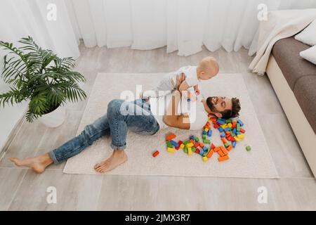 Ad angolo alto padre piano di gioco casa con il bambino Foto Stock