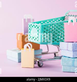 Carrello della spesa con confezioni regalo colorate Foto Stock