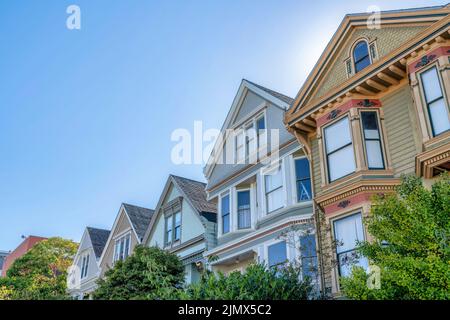 Vista ad angolo basso obliquo delle case con scandole decorative e finestre a baia a San Francisco, CA. Ci sono due case a tre piani sulla destra Foto Stock