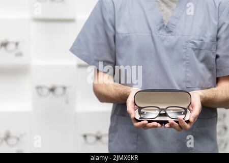 Vista frontale uomo che regge coppia di occhiali custodia Foto Stock