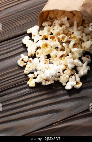 Spuntino a base di mais in sacchetto di carta sul primo piano del tavolo di legno Foto Stock