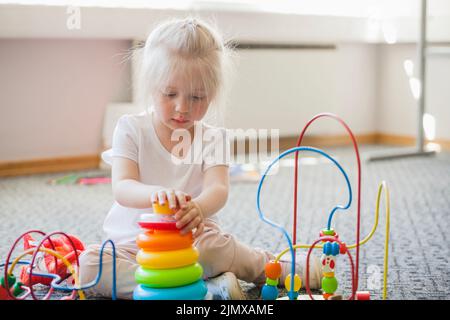 Concentrato il bambino che passa il tempo con i giocattoli Foto Stock