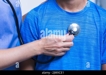 Primo piano della mano del dentista che esamina il paziente con stetoscopio Foto Stock