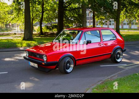 1983 80s anni Ottanta Red VW Volkswagen Golf GTI in arrivo all'annuale Stanley Park Classic Car Show nei Giardini Italiani. Stanley Park Classics Yesteryear Motor Show Hosted by Blackpool Vintage Vehicle Preservation Group, UK. Foto Stock