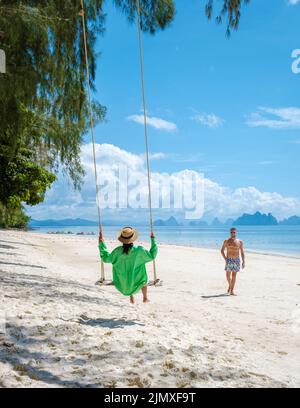 Coppia uomini e donne sulla spiaggia dell'isola tropicale Naka Island vicino Phuket Thailandia Foto Stock