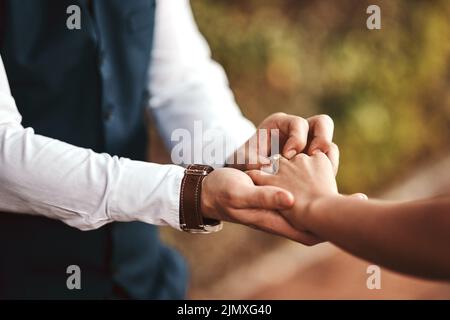 Questo è un segno del mio amore per te, un uomo irriconoscibile che mette un anello sul suo dito. Foto Stock