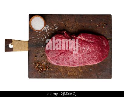 Filetto di manzo crudo si trova su un tagliere e spezie per la cottura Foto Stock