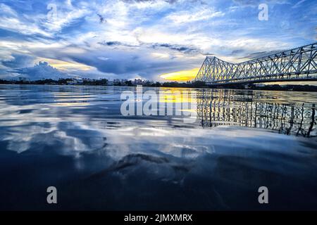 Kolkata, India. 07th ago 2022. Momenti al tramonto dal Ghat Jagannath di Kolkata con l'iconico ponte Howrah. (Foto di Avishek Das/SOPA Images/Sipa USA) Credit: Sipa USA/Alamy Live News Foto Stock