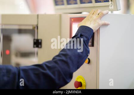 L'operatore controlla le apparecchiature industriali tramite il pannello di controllo con schermo a sfioramento. Messa a fuoco selettiva. Foto Stock