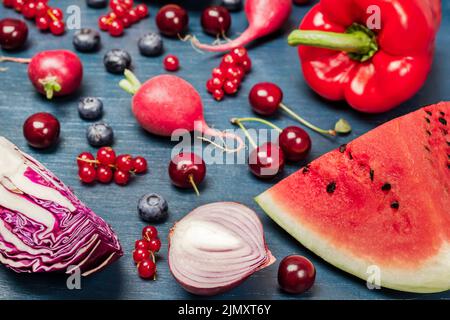 Verdure rosse e frutta su sfondo blu. Vista dall'alto. Foto Stock