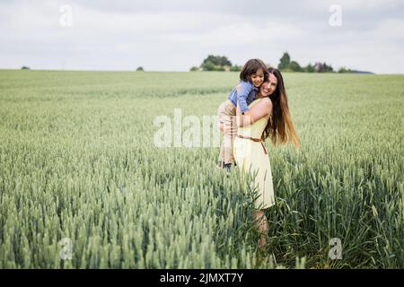 Madre e piccolo bel bambino che cammina nel campo Foto Stock