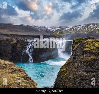 Pittoresca cascata Sigoldufoss vista autunno. Stagione che cambia nelle Highlands meridionali dell'Islanda. Foto Stock
