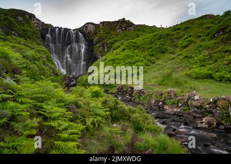 Una vista della cascata di Clashniesse nelle Highlands scozzesi in alta estate con lussureggianti felci verdi in primo piano Foto Stock