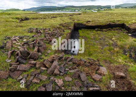 Molte fette di torba fresche che si asciugano in estate in un paesaggio di brughiera scozzese sull'isola di Skye Foto Stock
