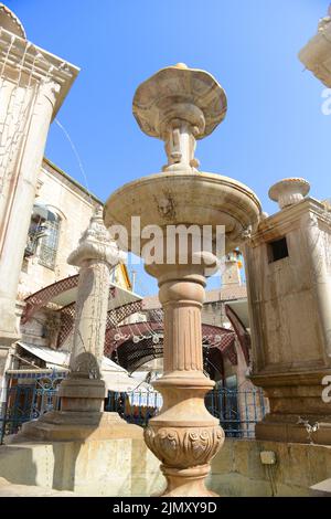 Una gargoyle a forma di faccia umana della fontana d'acqua costruita nel 1903 dal Patriarcato greco-ortodosso in stile neo barocco. Gerusalemme, Israele. Foto Stock