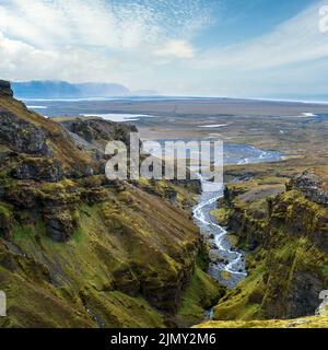 Splendida vista autunnale dal Canyon di Mulagljufur al ghiacciaio di Fjallsarlon con la laguna di ghiaccio di Breidarlon, Islanda e Oceano Atlantico in lontano. Si trova all'estremità sud di Foto Stock