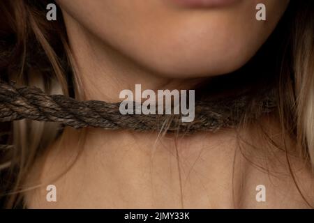 ragazza con una corda intorno al collo, traffico di esseri umani, schiavitù, potere sulle persone, una corda intorno al collo di una persona Foto Stock