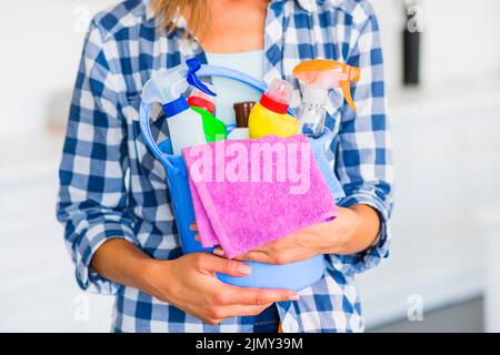 Janitor a sezione centrale che tiene la benna blu delle attrezzature di pulizia Foto Stock