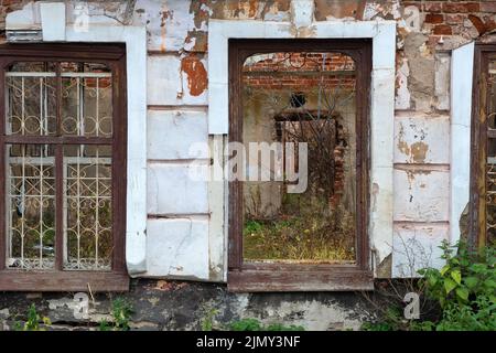 Finestre e muri di una vecchia casa in rovina in autunno Foto Stock