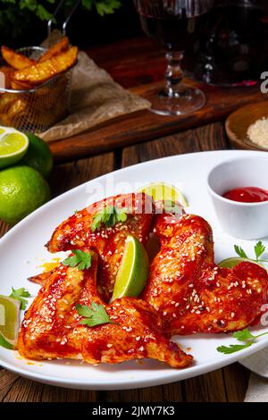 Ali di pollo con spicchi di patate e zam. Foto Stock