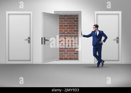 Uomo d'affari che non si affaccia uscita con la porta di mattoni Foto Stock