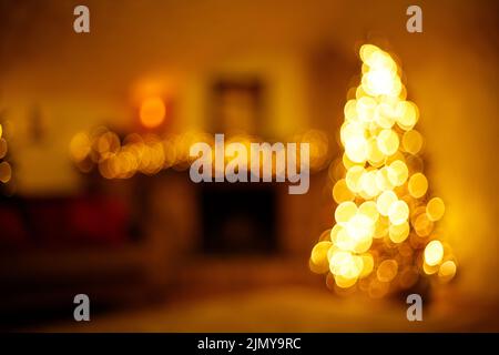 Caldo nuovo anno casa interno con albero di natale e illuminazione festiva, sfondo sfocato vacanza Foto Stock