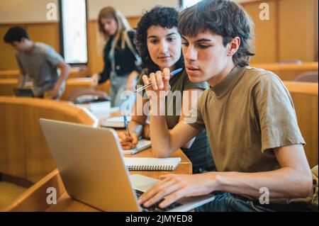 Gli studenti analizzano i dati sul notebook durante la lezione Foto Stock
