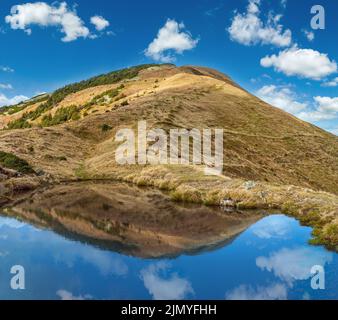 Piccolo e pittoresco lago con le nuvole che si riflettono sul Monte Strymba. Bella giornata autunnale nei Monti Carpazi vicino a Kolochav Foto Stock