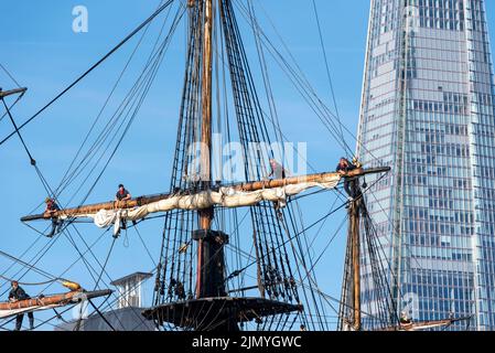 Tower Bridge, Londra, Regno Unito. 8th ago, 2022. Goteborg di Svezia è una replica a vela della svedese East Indiaman Goteborg i, lanciata nel 1738, e sta visitando Londra per accogliere i visitatori a bordo. La replica di legno fu lanciata nel 2003 e visitò Londra l'ultima volta nel 2007. Ha navigato sul Fiume Tamigi in mattinata per passare sotto il Tower Bridge aperto prima di svoltare e passare di nuovo sotto e dirigersi verso il Thames Quay a Canary Wharf, dove sarà aperto ai visitatori. I membri dell'equipaggio saliscono sui montanti, con lo Shard Foto Stock