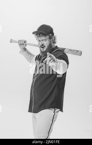 Sfida. Appassionato giocatore di baseball maschile che indossa una divisa sportiva retrò e tiene la mazza isolata su sfondo bianco. Batteria da baseball d'epoca Foto Stock