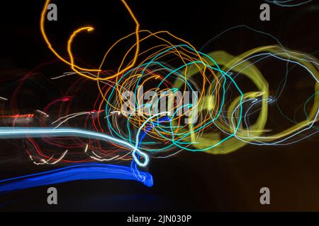 Un primo piano di belle luci colorate al neon in movimento circolare al buio Foto Stock