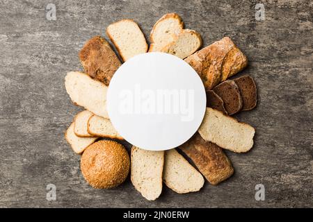 Minimal carta bianco mockup su sfondo di tipi di pane fatto in casa. Diversi tipi di pane fresco come sfondo, vista dall'alto con spazio per il tuo tex Foto Stock